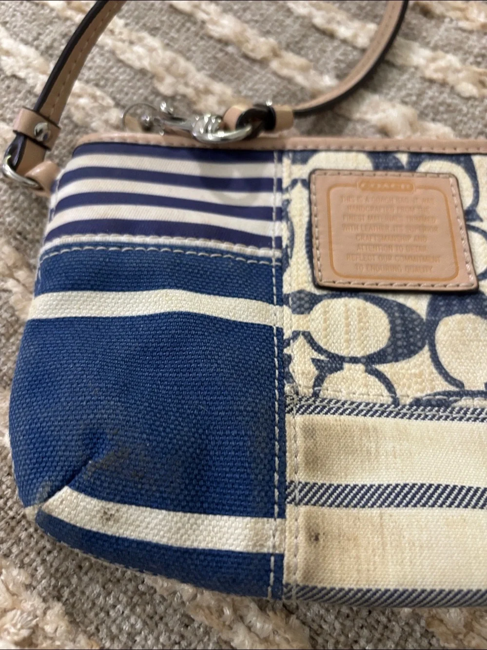 Coach wristlet featuring signature patchwork print in navy and cream